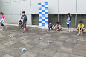 Photo of children testing solar cars outside event venue