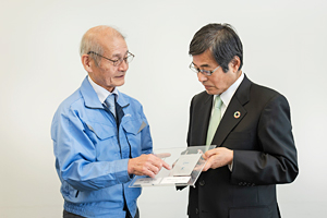 Photo of Dr. Yoshino and Chairman Ishizuka exchanging views regarding all-solid-state lithium-ion battery