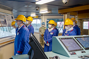 Photo of Minister Kajiyama observing installation of liquid hydrogen storage tanks and other equipment 