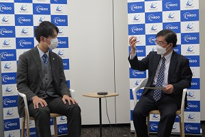 Photo of Program Director Dr. Yamaji (right) engaged in discussion with Moonshot Ambassador Muraki (left)