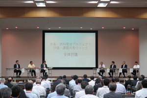 Photo of committee members onstage engaged in panel discussion of conference presentations