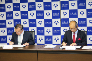 Photo of NEDO Executive Director Masayoshi Watanabe and Dr. Yasufumi Kaneda, Senior Executive Vice President of Osaka University, signing MOC