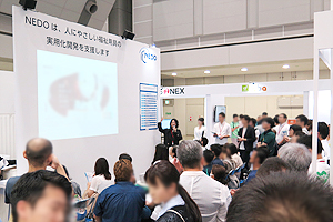 Photo of presentation at NEDO booth regarding project results