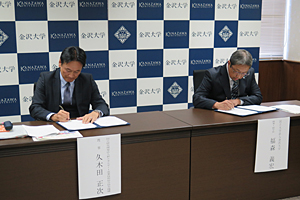 Photo of NEDO Executive Director Shoji Kukita and Kanazawa University Vice President of Community Cooperation Yoshihiro Fukumori signing MOC