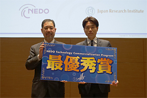 最優秀賞を受賞した株式会社カーム・ラーナ（右）と、及川副理事長（左）の写真