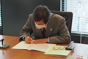 協定書に署名するNEDO石塚理事長の写真