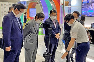 大会視察の様子の写真。左から長坂経済産業副大臣、NEDO石塚理事長、愛知県大村知事。