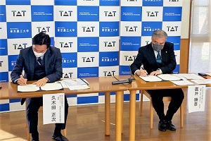 Photo of NEDO Executive Director Kukita (left) and TUAT Vice President Naoi (right) signing agreement