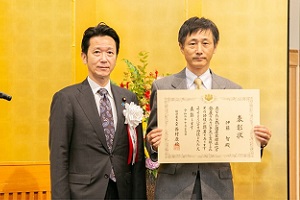 長峯 誠　経済産業大臣政務官兼内閣府大臣政務官（左）から表彰状を授与された伊藤ユニット長（右）の様子の写真