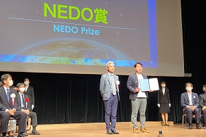 NEDO吉田イノベーション推進部長より、NEDO賞を授与された受賞者（SpaLCe）の写真