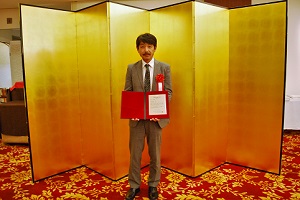 授与された表彰状を手にする廣瀬主査の写真