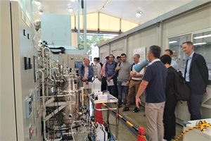 CO2を化学品に変換するバイオリアクターを見学する参加者の写真