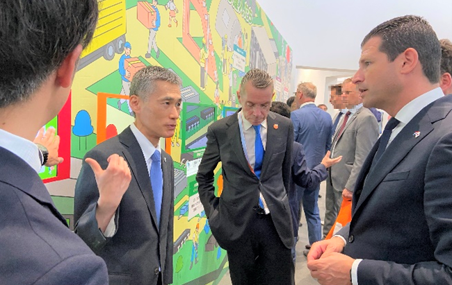 Photo of His Excellency Dirk Beljaarts, the Minister of Economic Affairs of the Netherlands, visiting the exhibition called Next-Generation Green Data Centers that showcases NEDO-supported innovations