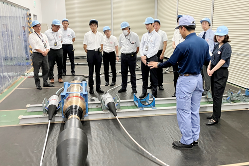 高効率海底光中継器の説明をうけるネド西村理事の写真