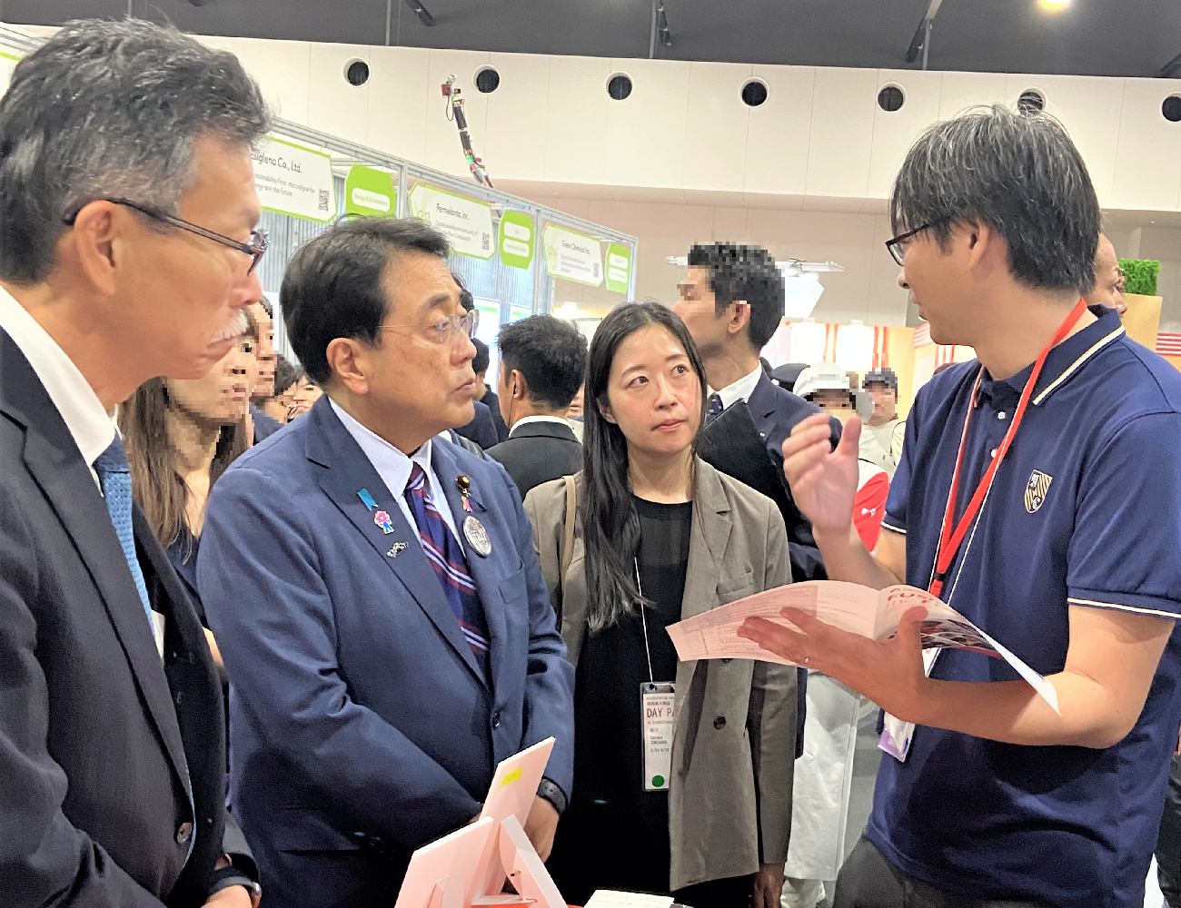 スタートアップ企業のブースで説明を聞く赤澤スタートアップ担当大臣とネド弓取理事の写真