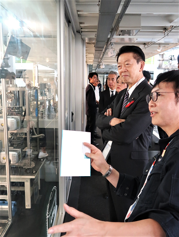 名古屋大学のダック実証機を視察する大臣と説明者の則永プロジェクトマネージャーの写真