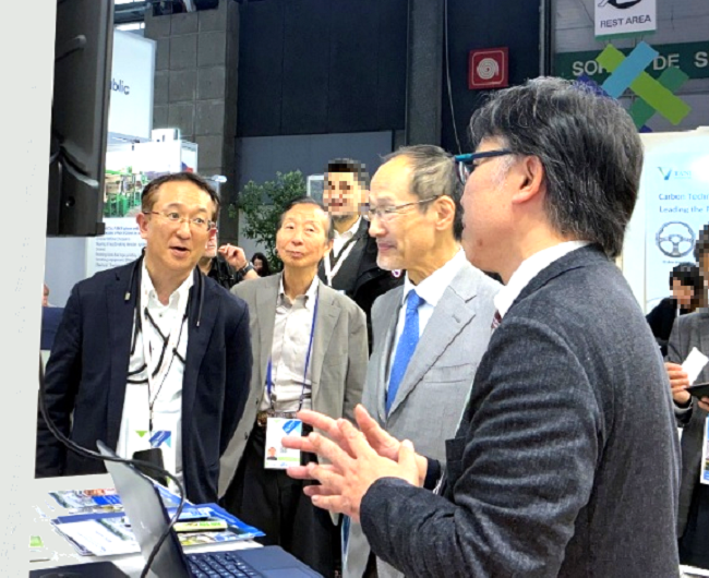 Photo of His Excellency Mr. SUZUKI Hideo, Ambassador of Japan to France receiving an explanation at the NEDO booth
